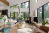 A cozy modern living room of a Montana Vrbo with soft brown furniture, large rug and woodburner