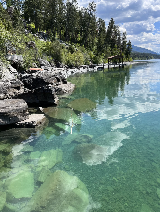 The private rocky shoreline, with private dock, of this Montana Vrbo