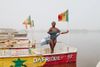 Jessica Nabongo stands aboard a red, yellow and green boat on on Lac Rose in Senegal