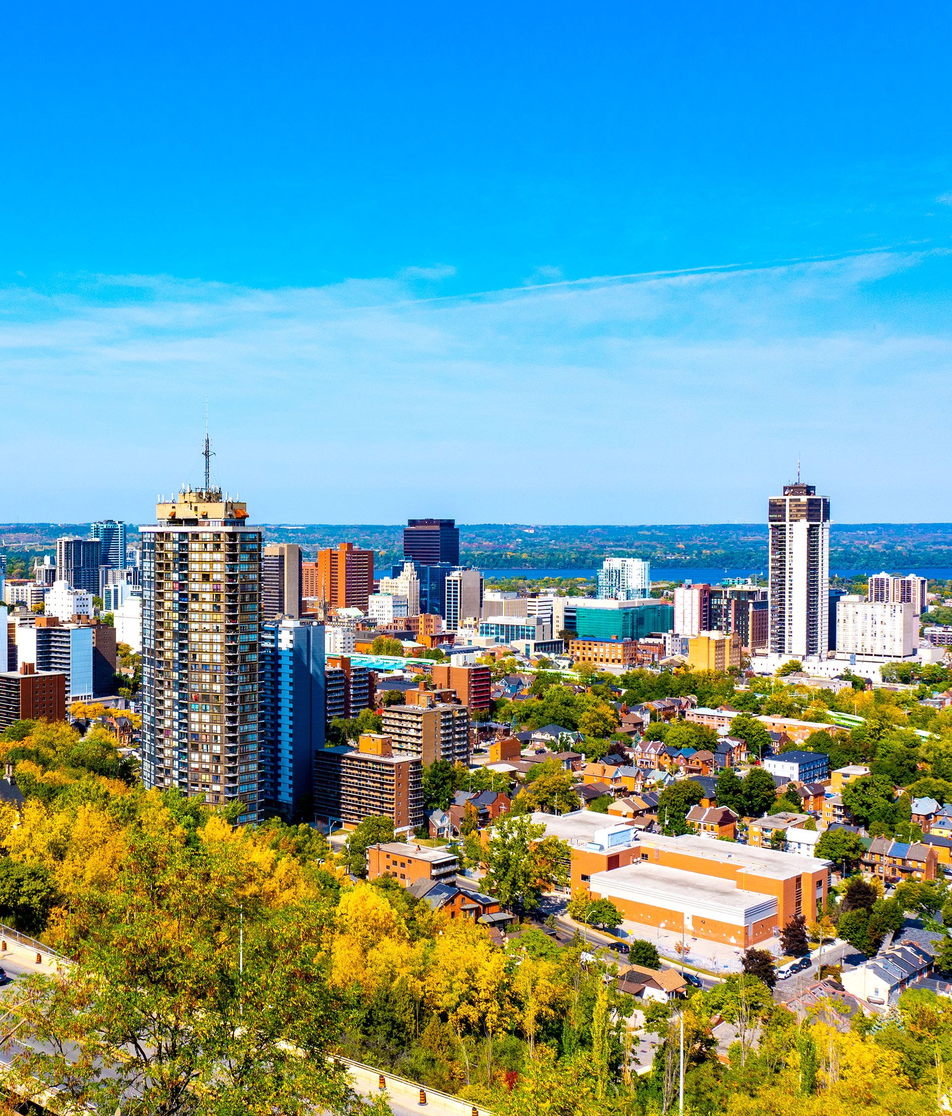 Aerial view of city with blue skies and tall buildings.