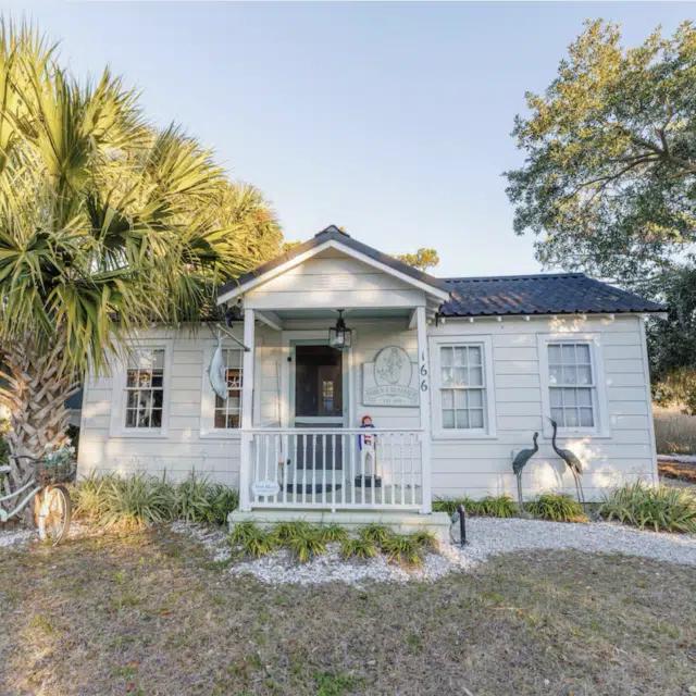 Exterior view of the white clapboard Siren & Seafarer Cottage on Tybee Island, Georgia