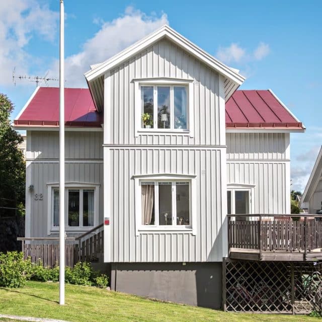 A wood-paneled vacation rental with a red roof 