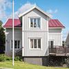 A wood-paneled vacation rental with a red roof