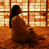 A woman sits cross-legged in a salt chamber at Spa L.A.