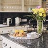 A tray on a counter is loaded with croissants, orange juice, and coffee, part of a hearty breakfast, as prepared in the Vrbo's well-equipped kitchen