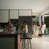 A multi-generational family bringing groceries home to to a modern vacation rental kitchen