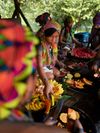 Female members of the Emberá community seated on the ground, preparing tropical fruit platters, Parara Purù, Panama
