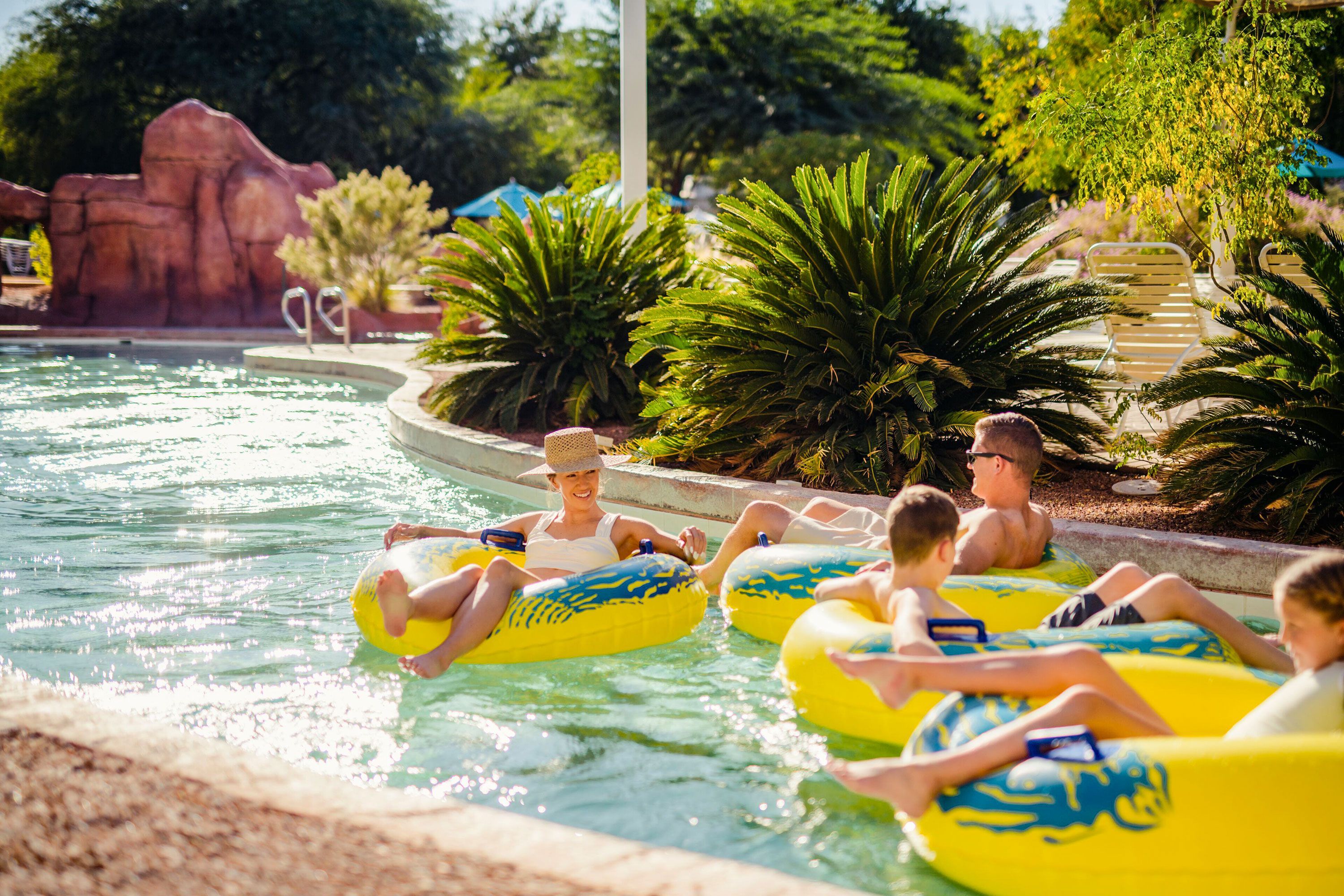 A family of four float down a channel at a water park.