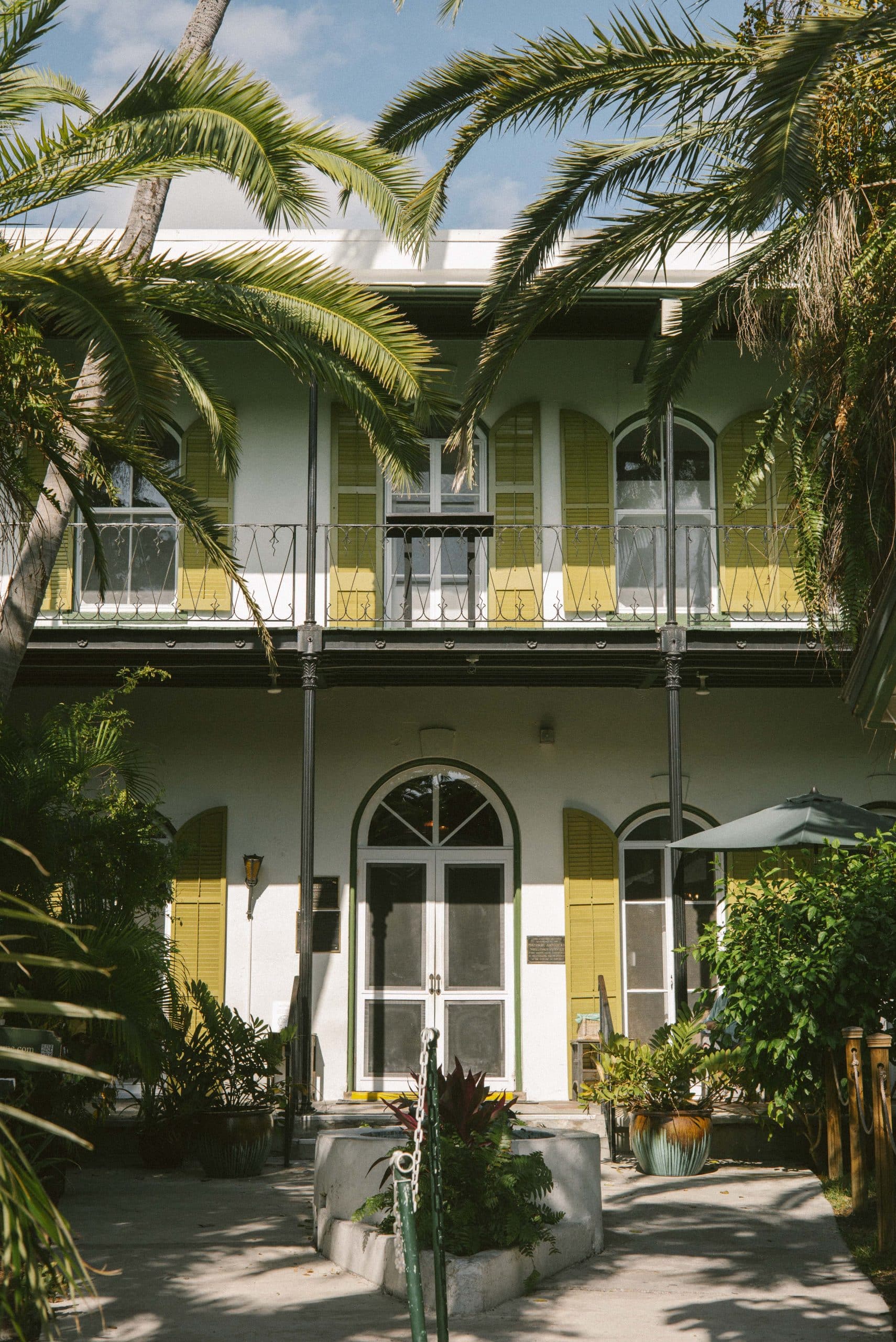 Ernest Hemingway's house in Key West, Florida, with its whitewashed walls, yellow shutters and palm trees