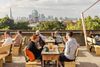Groups of people have drinks on a sunny day at the rooftop bar Frank's Café in Peckham, London, England