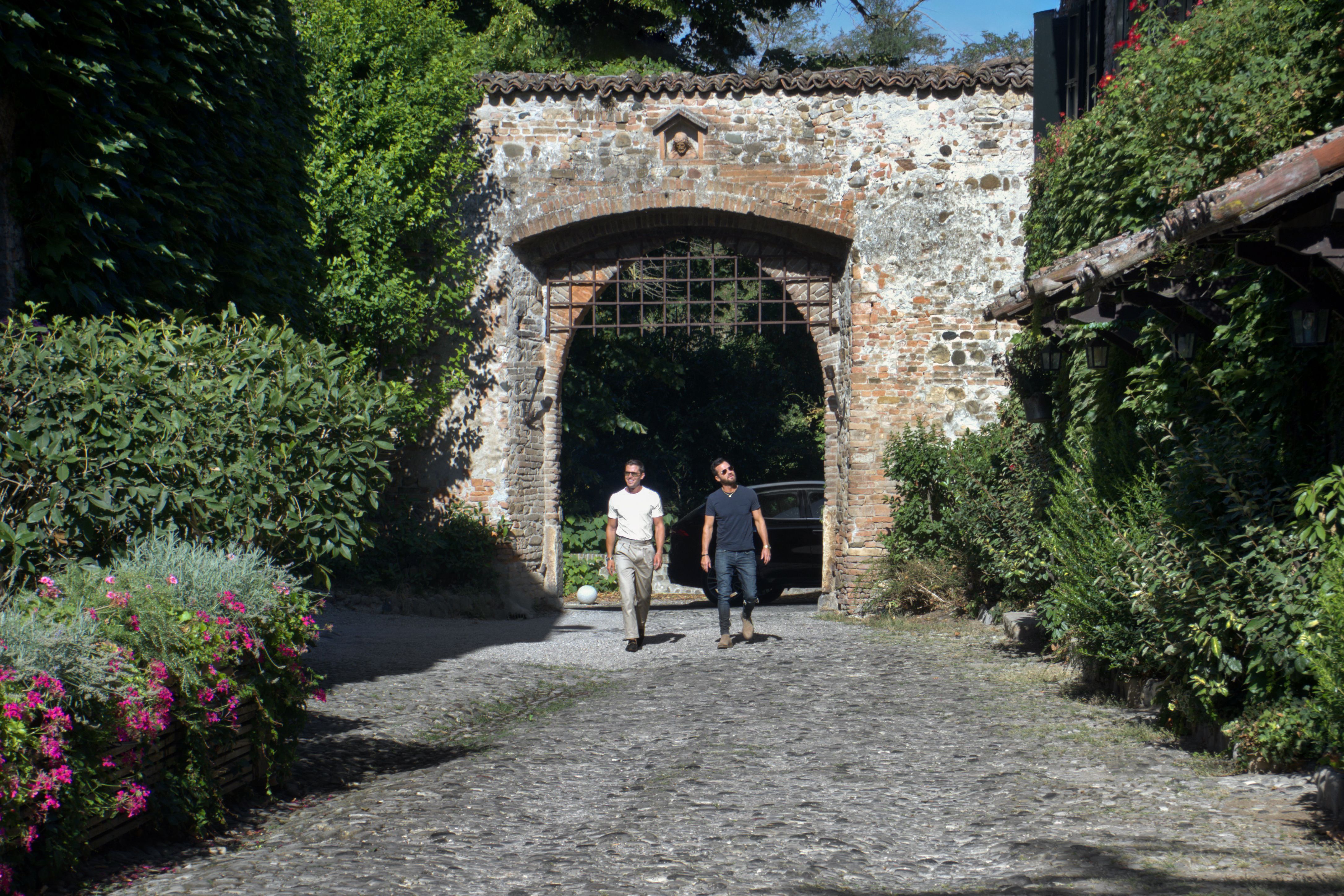 Antoni Porowski and Justin Theroux enter the stone gateway at famed restaurant Locanda del Falco in Rivalta. Photo: National Geographic/Rebecca Eishow