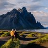 A man and a woman hiking along the coast.