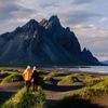 A man and a woman hiking along the coast.