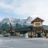 A grocery store at a crossroads backed by the snow-capped Rocky Mountains in the distance in Canmore, Canada