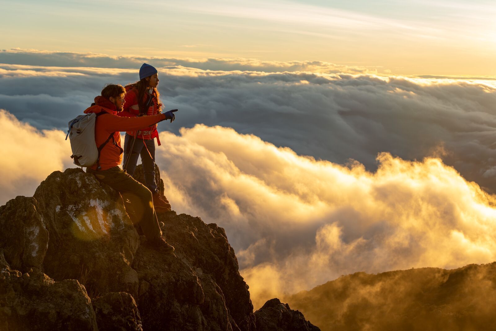 Two hikers at the top of the Barú Volcano, the highest peak in Panama, looking out over clouds beneath them