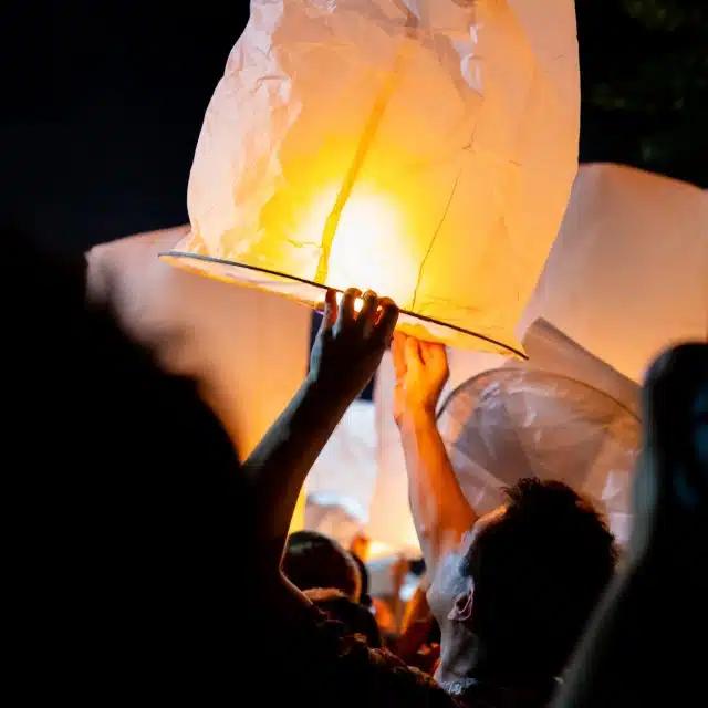 Paper lanterns held up in the night sky
