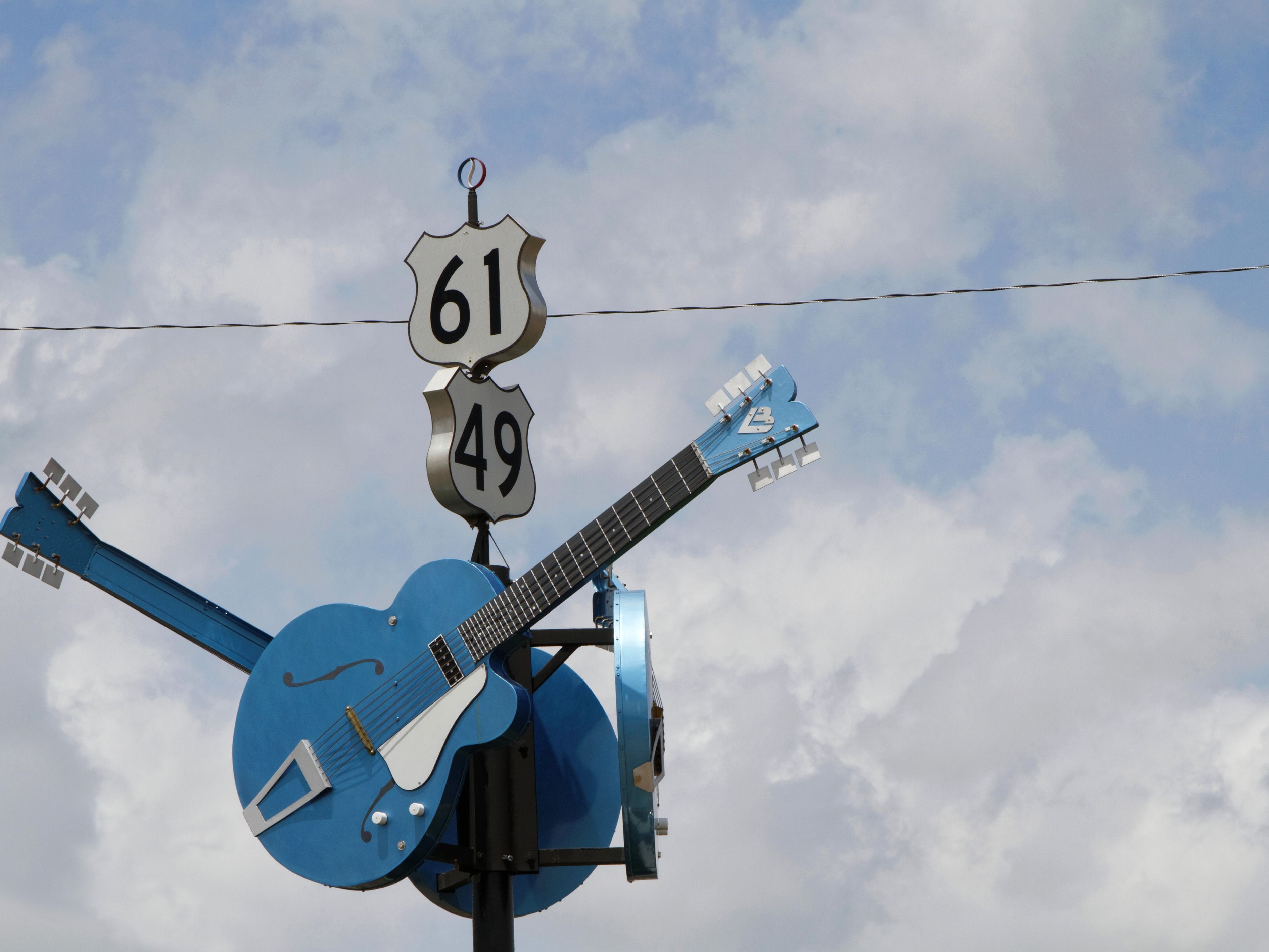 A signpost in Mississippi for state highway 61 and 49 with blue guitars