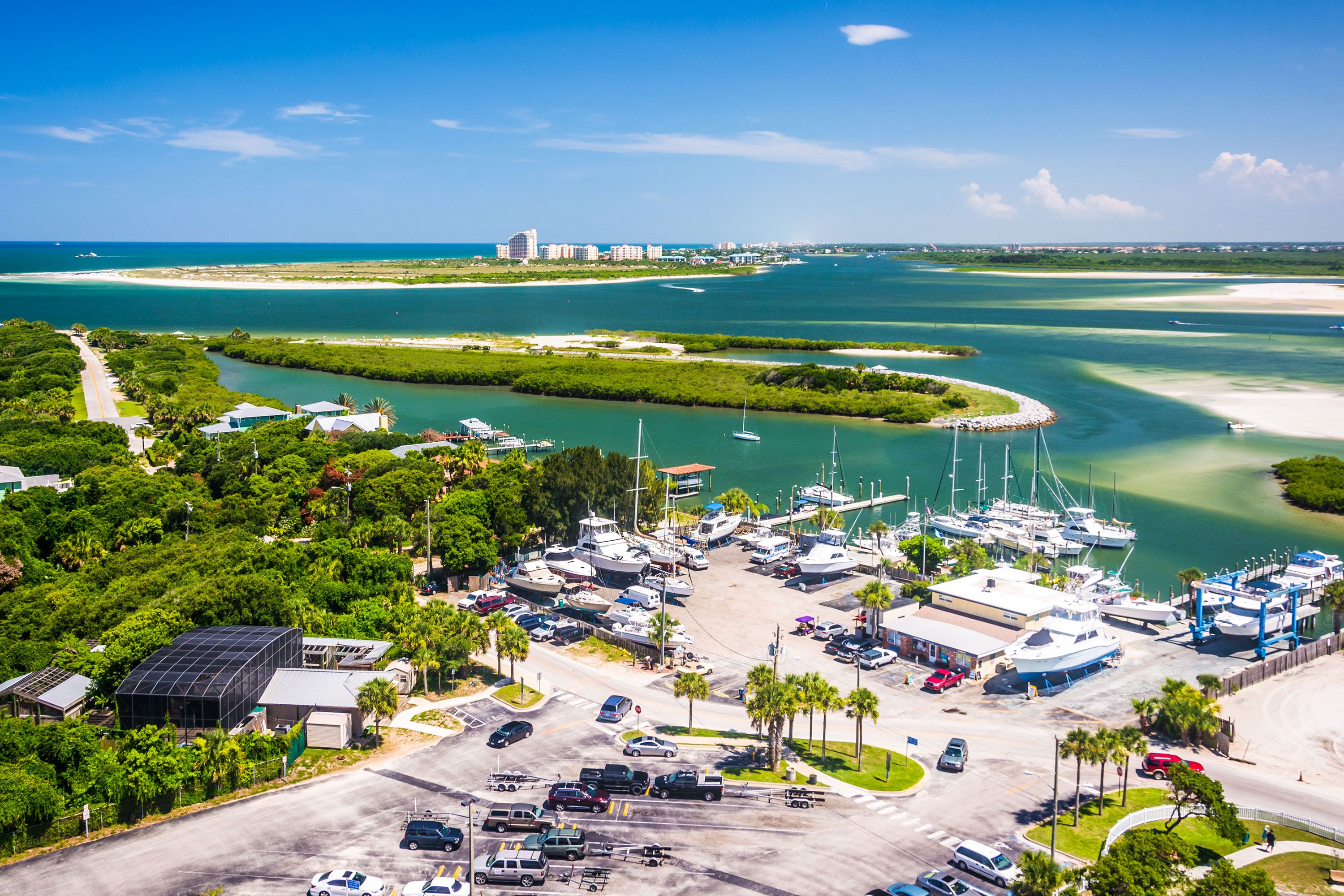 An aerial view of Ponce Inlet and the adjacent New Smyrna Beach in Florida, showing the ocean, inlet channel, and stretch of beach from above.