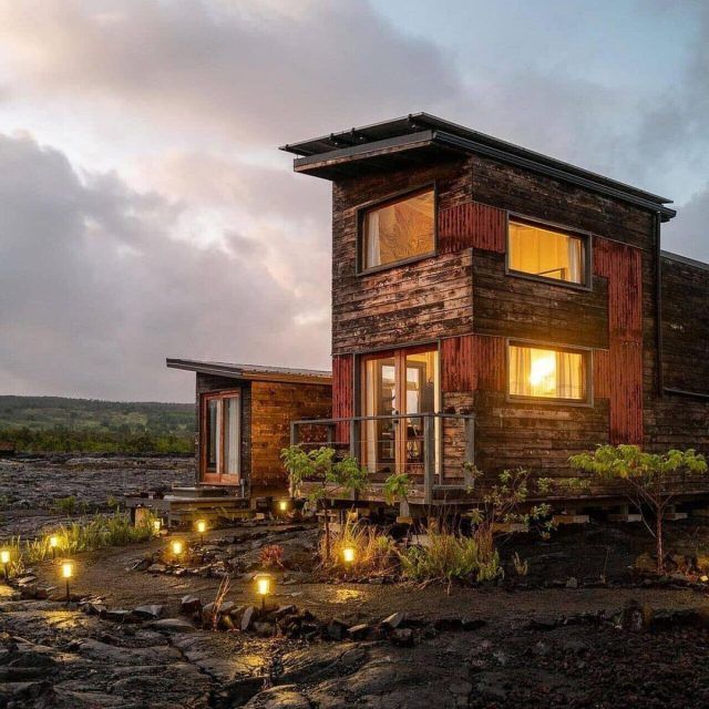Exterior view of the wooden-clad Phoenix House at dusk, with lights illuminating the walkway and windows