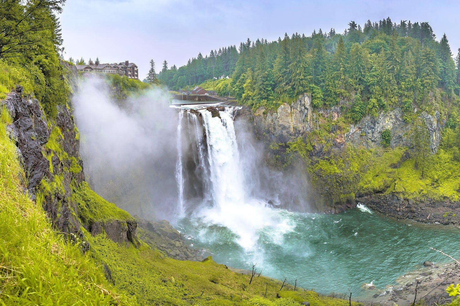 Snoqualmie Falls in the sunshine, surrounded by lush greenery