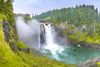 Snoqualmie Falls in the sunshine, surrounded by lush greenery