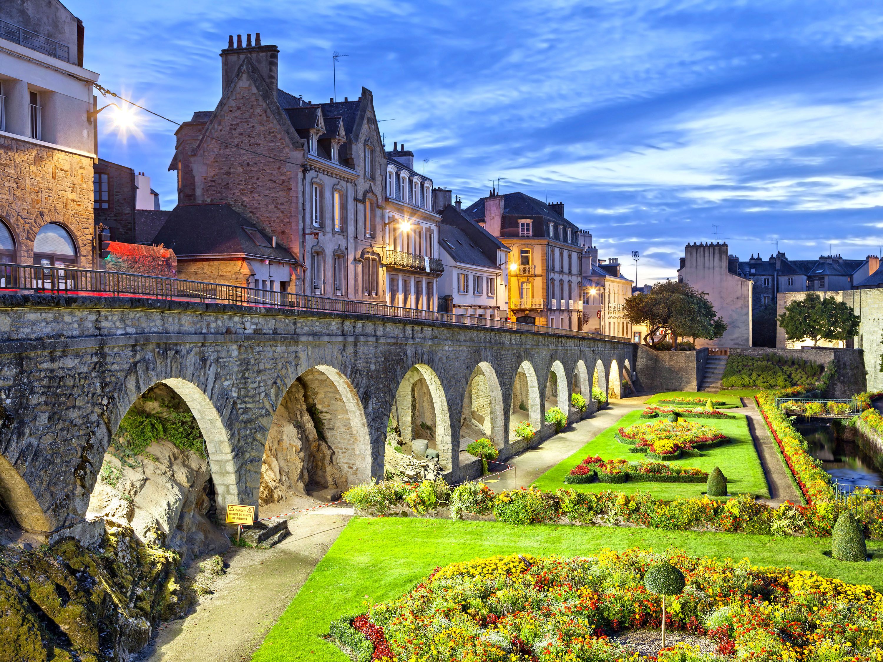 Stone bridge with arches and garden area.