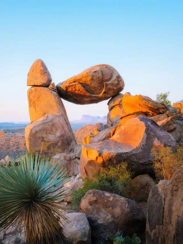Large rocks are piled up to form a window-like formation among desert shrubbery in Big Bend National Park, Texas 
