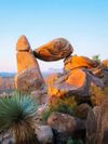 Large rocks are piled up to form a window-like formation among desert shrubbery in Big Bend National Park, Texas