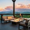 A view of mountains and pink clouds from the deck of a Vrbo in Gatlinburg, Tennessee, with a firepit and comfortable seating