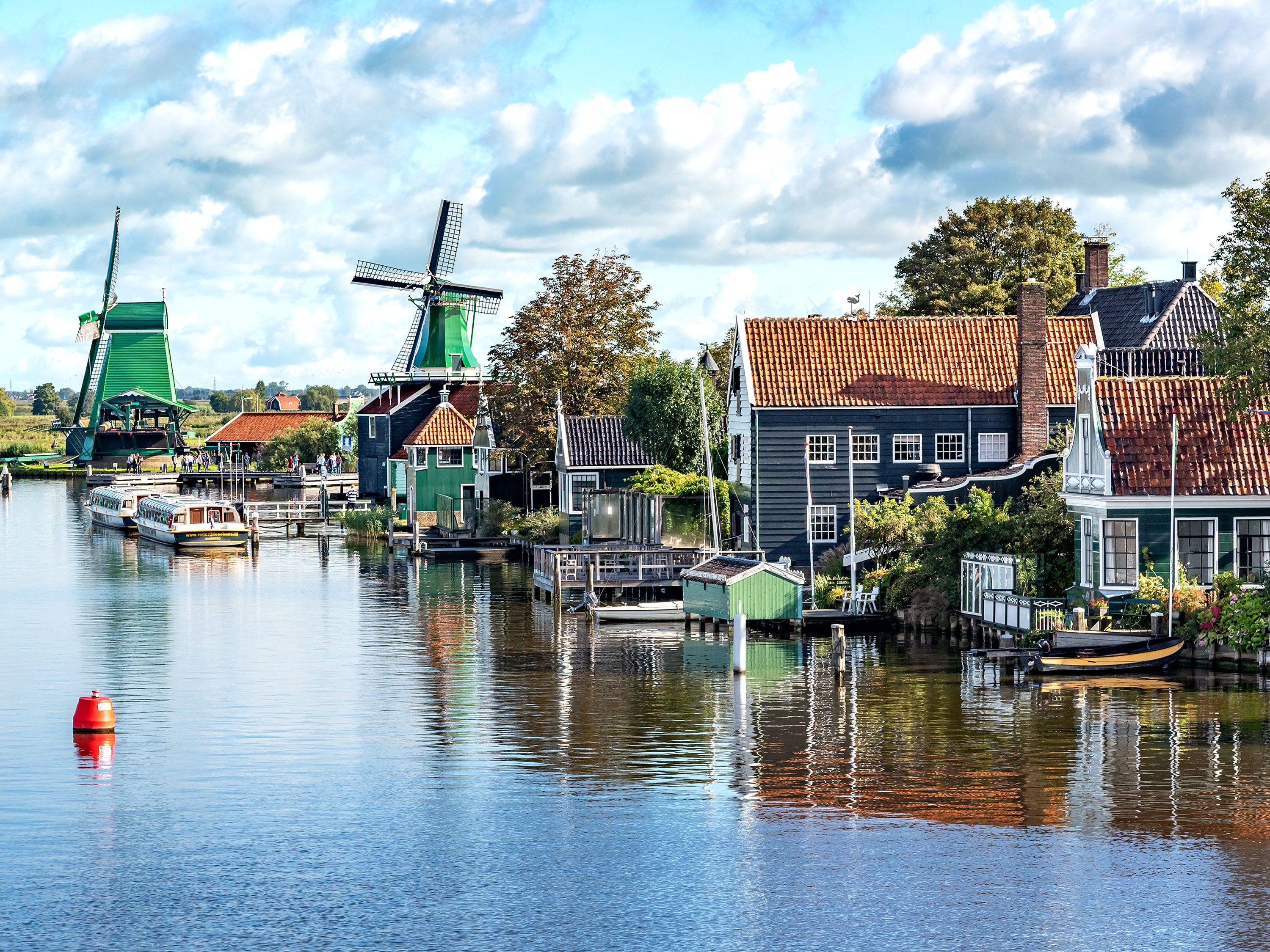 Calm water and lakefront homes with windmills.