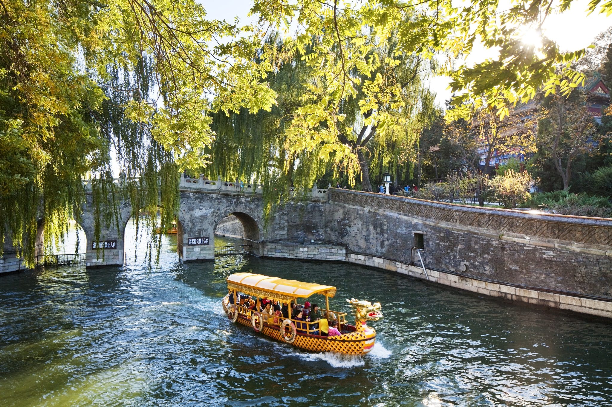 A tourist boat decorated like a dragon sails down a canal in Beijing