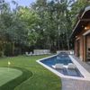 A putting green beside an angular pool at a Vrbo near Charlotte, NC
