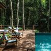 Inviting chairs sit beside a tranquil pool in the forest at the Datai Langkawi hotel, Malaysia