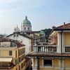 The Romanesque Duomo is seen over the top of buildings in Brescia, Italy