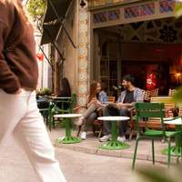 Green tables and chairs and decorative tiles form the frontage of Karabatak cafe in Karaköy, Istanbul