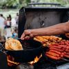 Yaniqueques are fried in a pot over a grill by a street vendor; the crispy bread is a Dominican street-food favorite