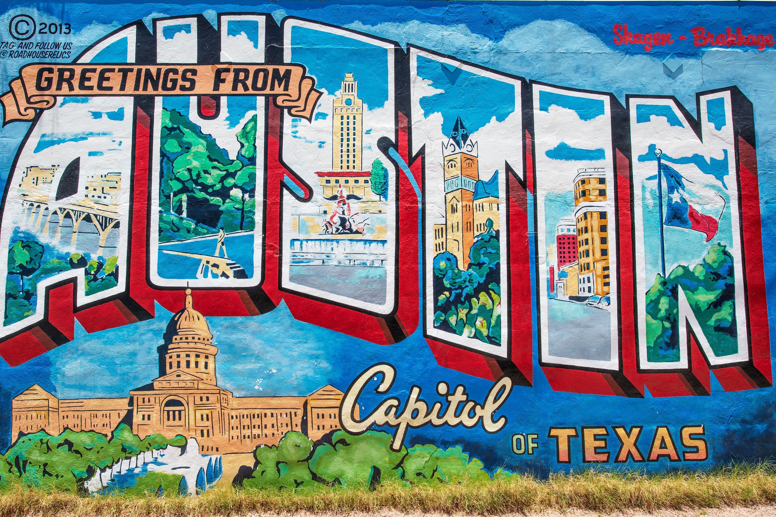 A colorful mural reading “Greetings from Austin Capitol of Texas” painted in retro postcard style on an outdoor wall with vibrant city imagery.