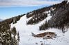 Aerial view of a big lodge on top of a snowy mountain with people walking around on a winter day in Whistler, British Columbia.