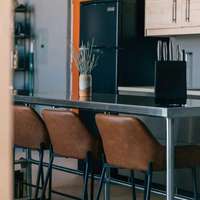 The metal kitchen island with brown leather high chairs at a Vrbo holiday rental property out in the desert in Terlingua, Texas