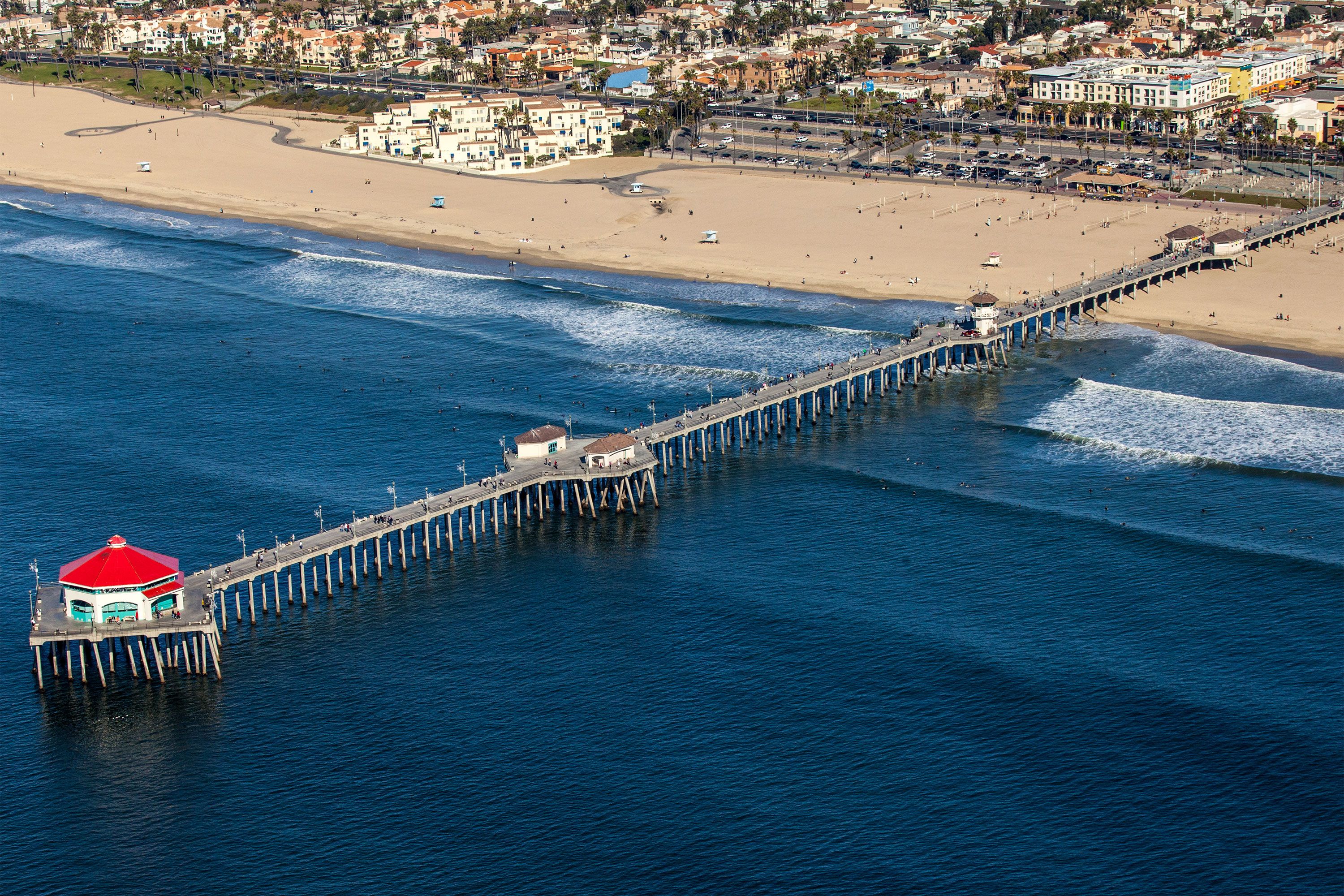 A pier with a red top extending into the ocean..