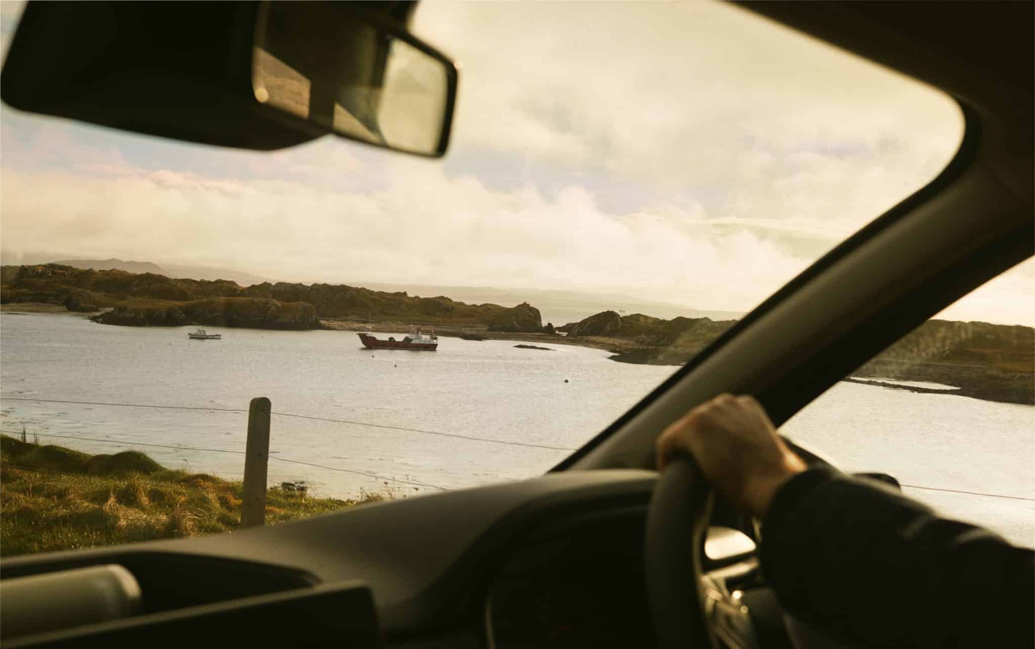 A view of islands, boats and the sea from a car driving Ireland's Wild Atlantic Way