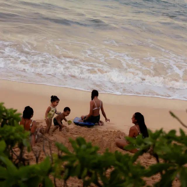 A family playing on the beach on Oahu