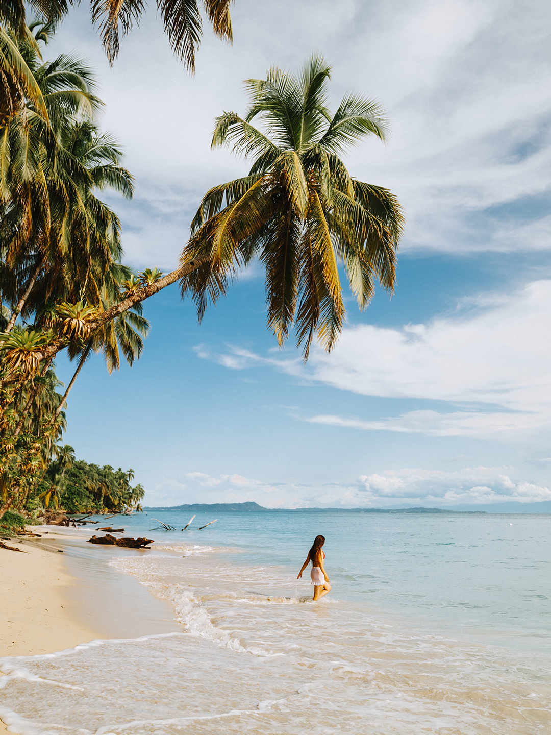 A person walks into the sea on a beach in Bocas del Toro in Panama