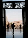 A man is shown in silhouette in the doorway of St. Peter's Basilica. Vatican City is visible behind him