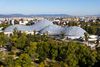 A large curved glass-and-metal dome surrounded by trees and parkland.