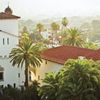 Palm trees and terracotta-roofed white buildings are seen from above in Santa Barbara, California