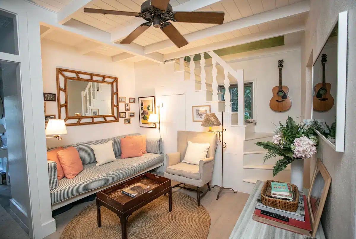 The living room, with striped sofa and wooden ceiling fan