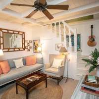 The living room, with striped sofa and wooden ceiling fan
