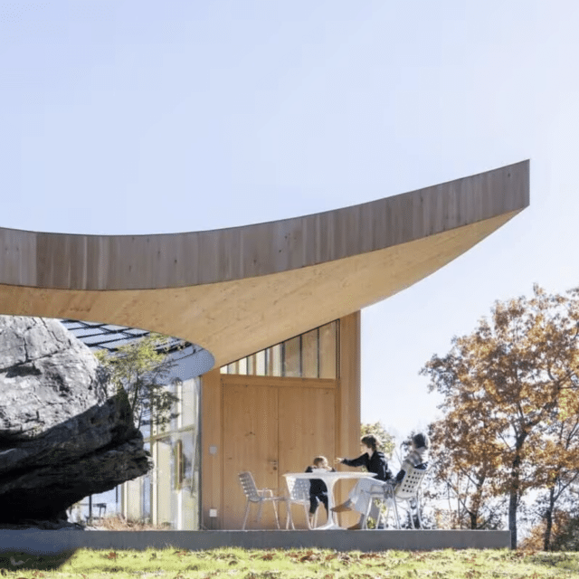 A family eats at a table under the curved, angular canopy of a Vrbo in Saugerties, New York