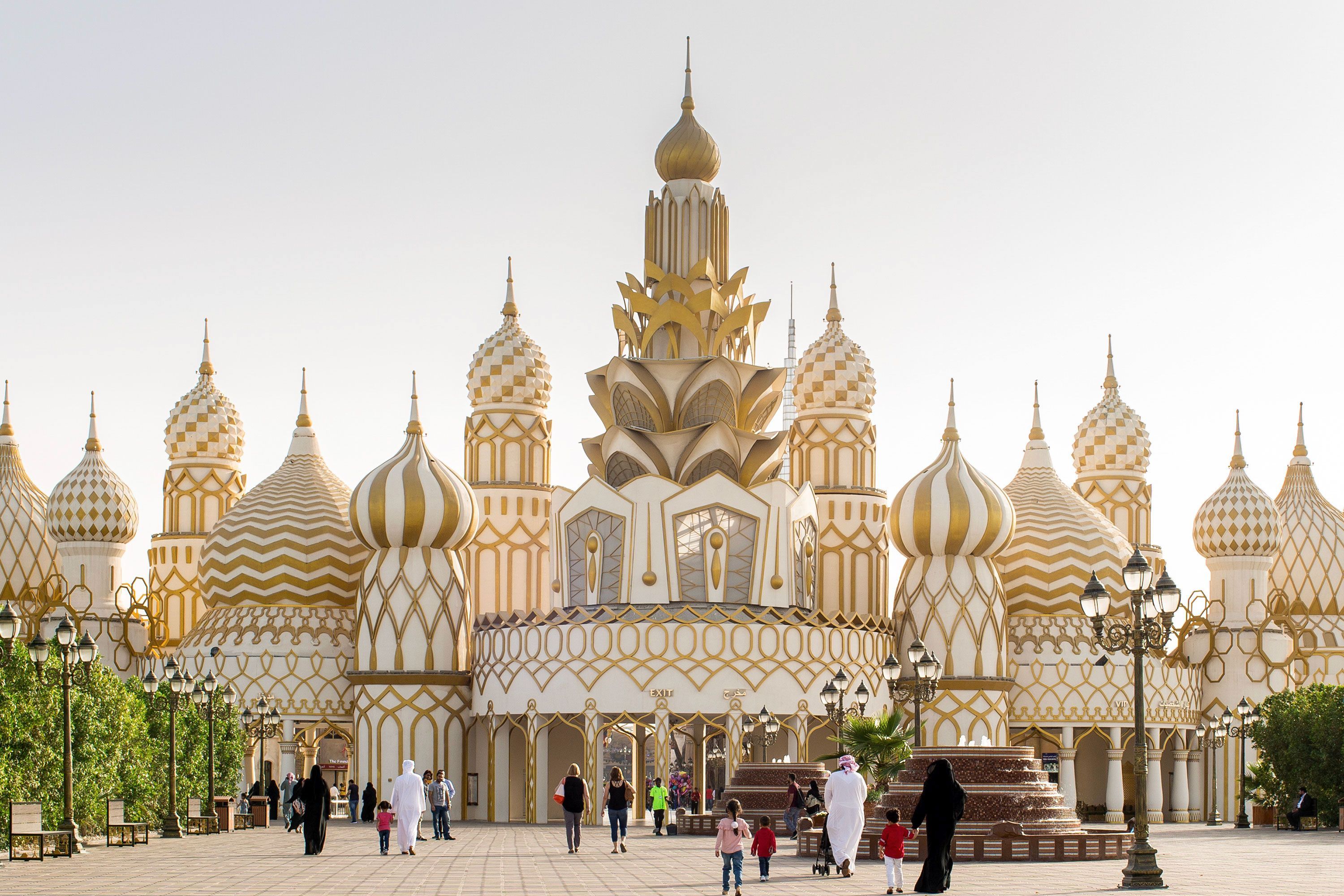 Exterior of Global Village in Dubai during the day, showing vibrant country-themed buildings and decorative façades against a sunny sky.